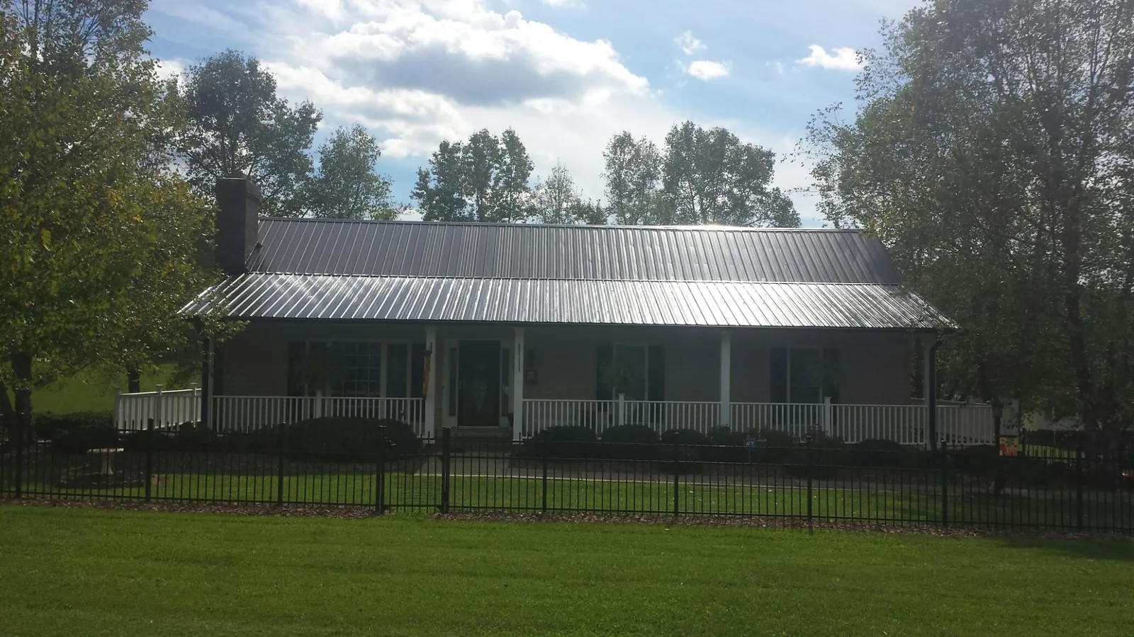 Gray metal roof on a brick ranch with a full width front porch — Gutter Guard Installation work by our crew in Viola