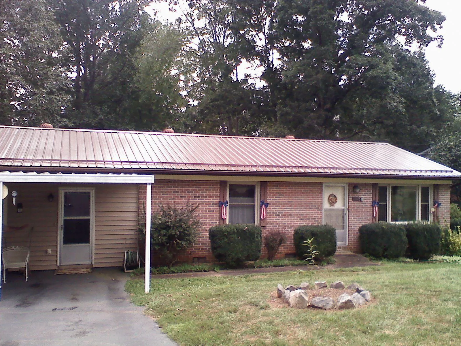 Bronze metal roof and carport on a brick ranch home — Roof Repair work by our crew in Viola